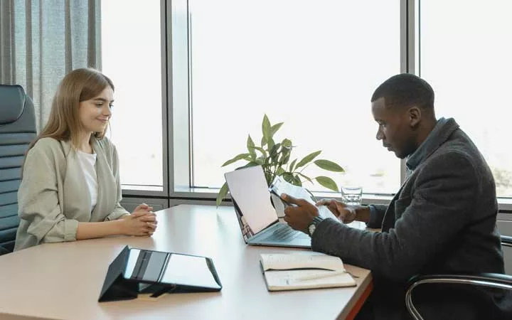 man discussing benefits package to new hire