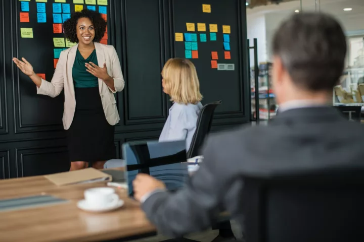 woman presenting in front of her HR team