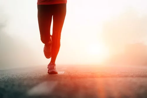 legs running on pavement in sunshine