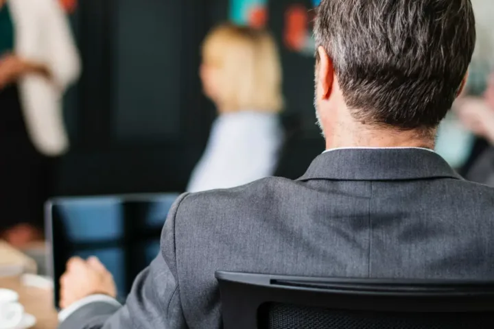 back of businessman sitting for a presentation