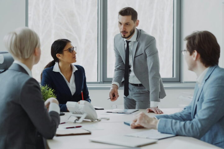 four business people having discussion in conference room