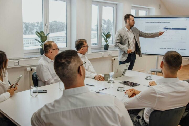 man presenting a slide of data to his team