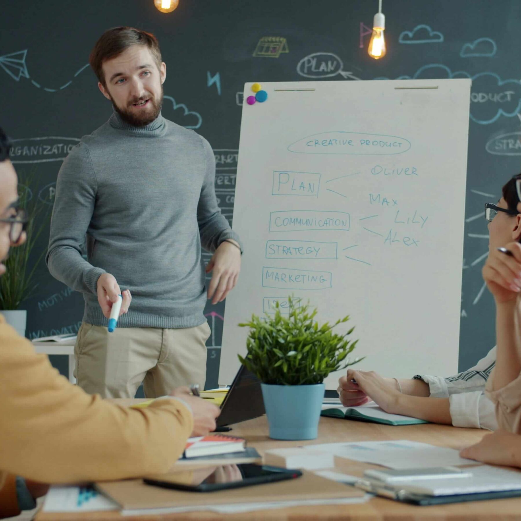 man presenting to team in conference room