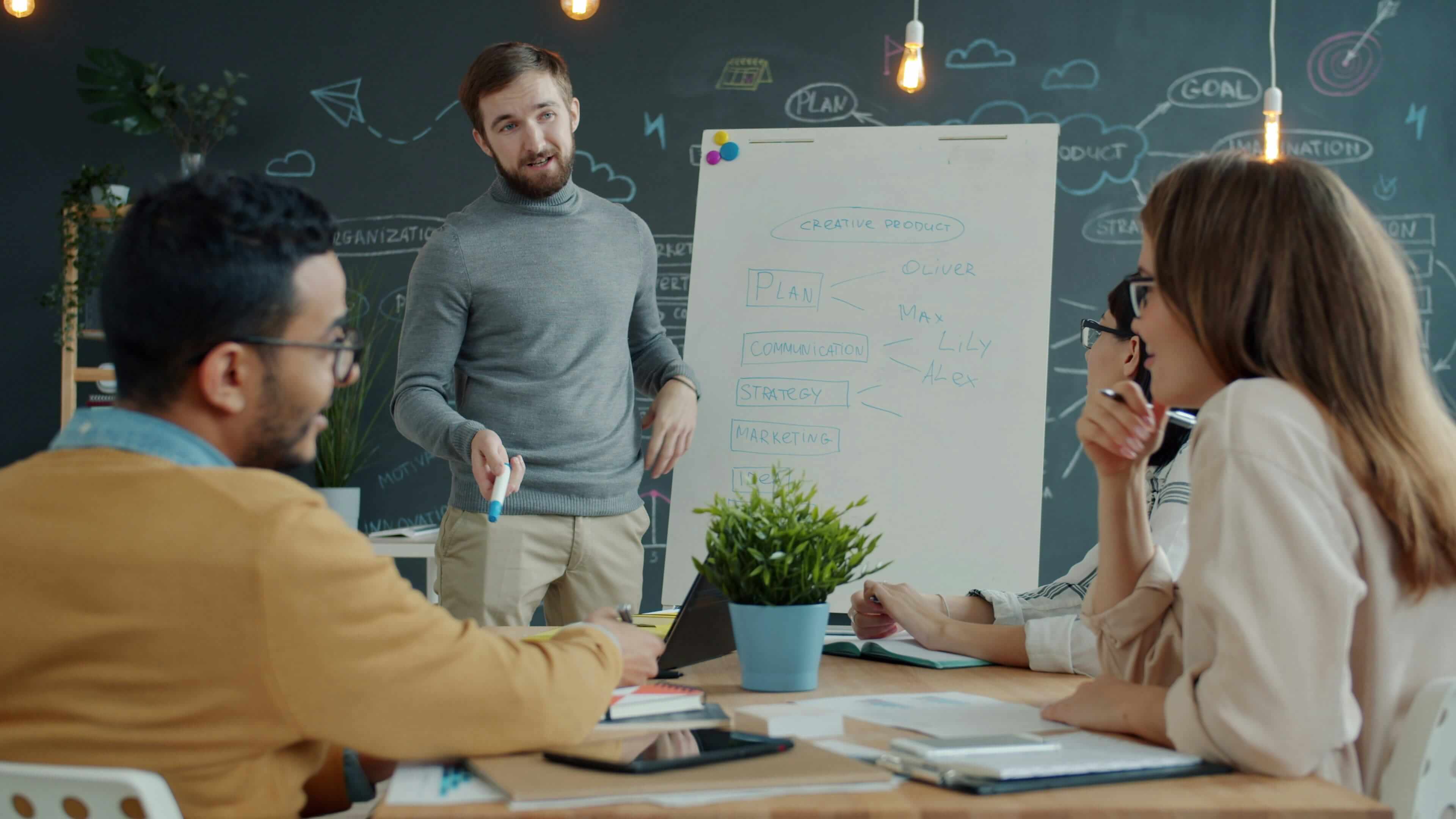 man presenting to team in conference room