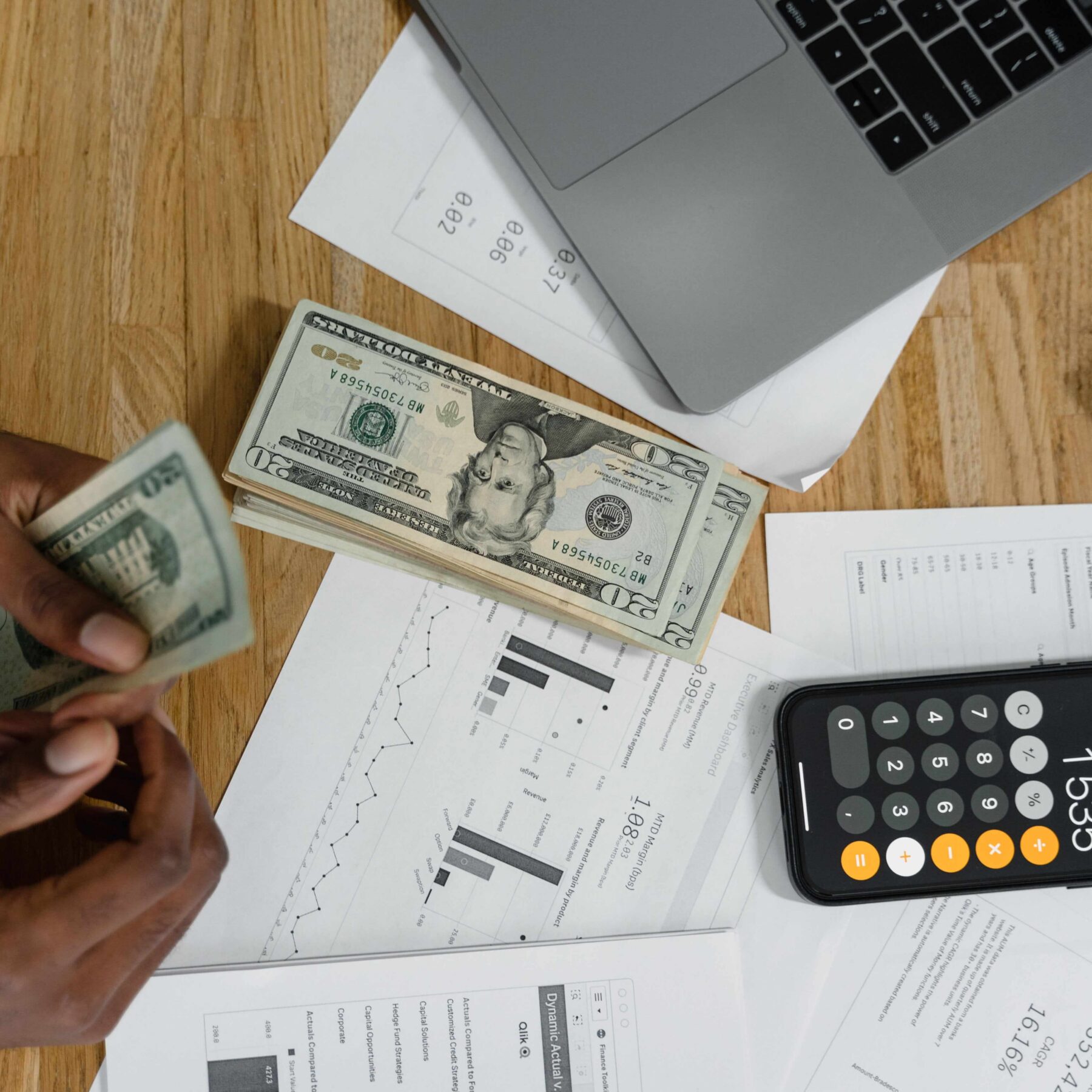 person budgeting with calculator and dollar bills