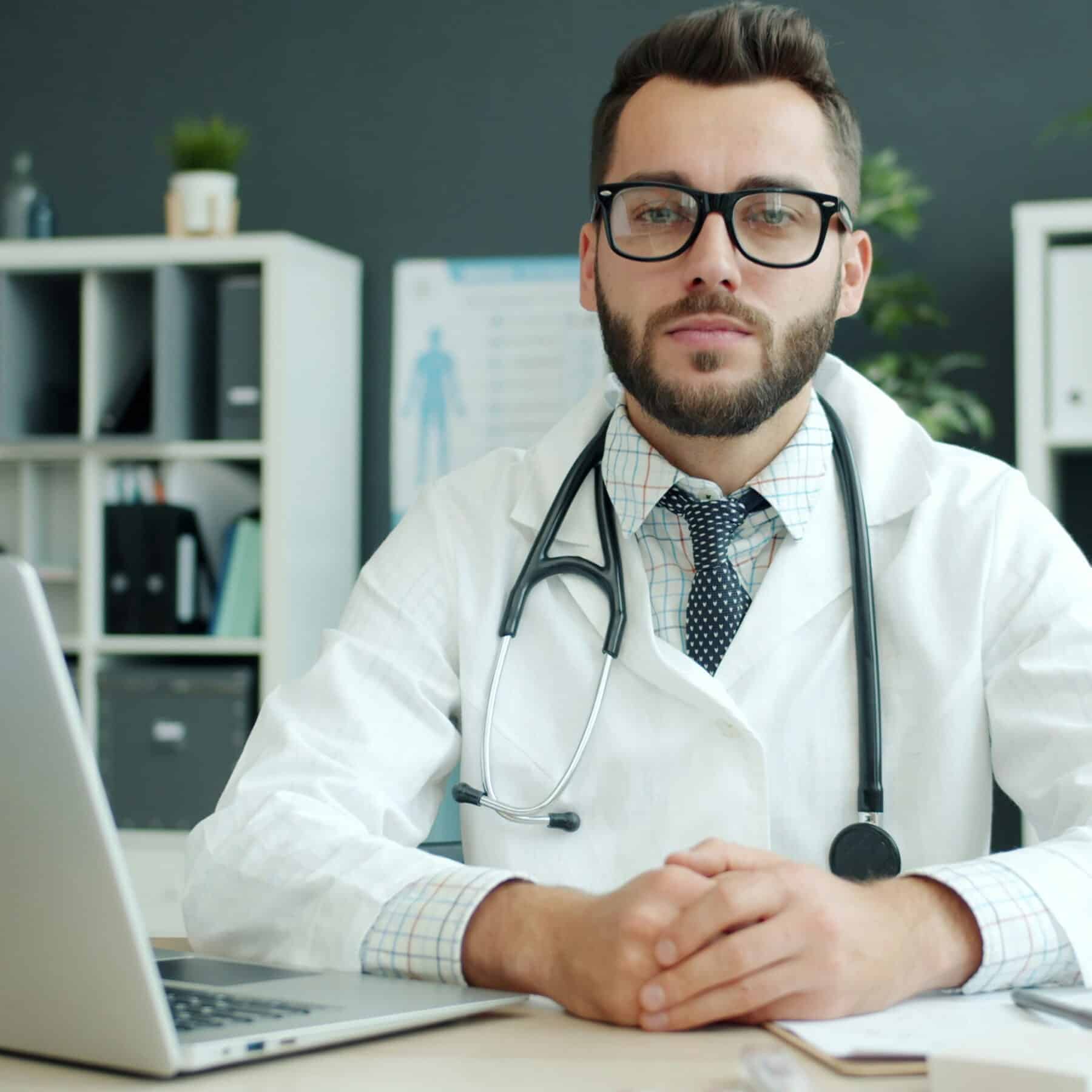doctor in white lab coat sitting at desk